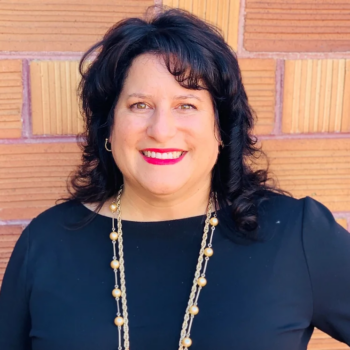 Smiling woman against brick wall