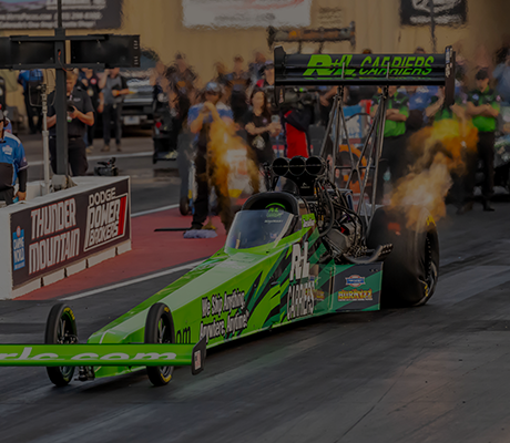 Green dragster racing on track