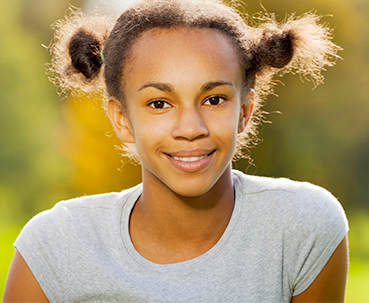 Smiling kid in sunshine outdoors